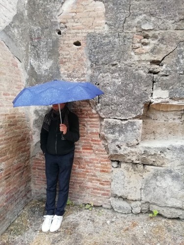 homme debout contre un mur sous parapluie